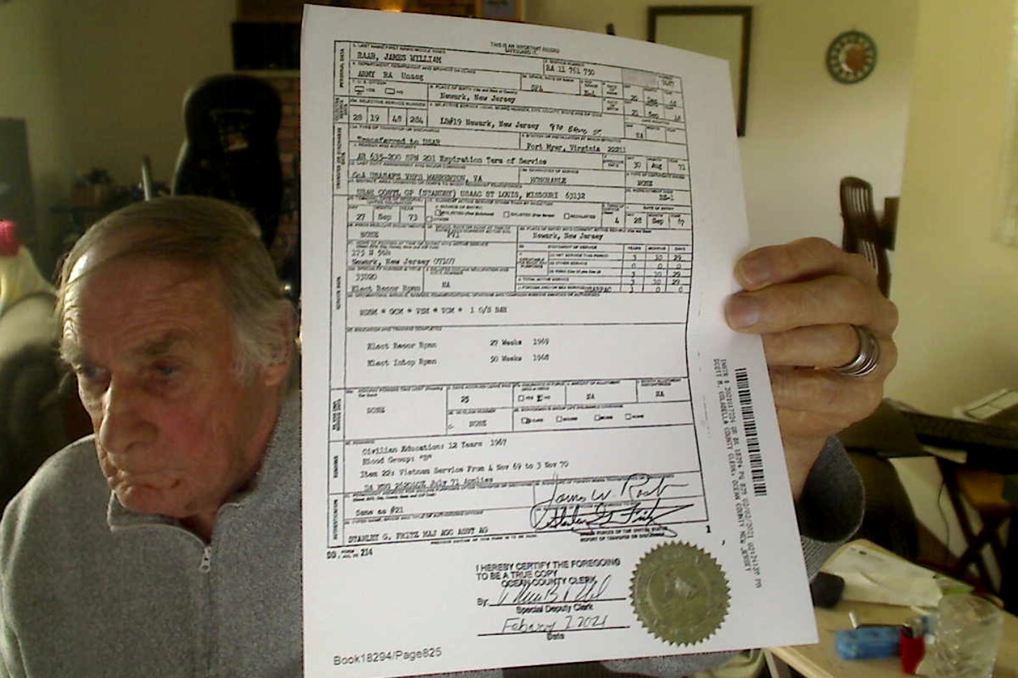 Vietnam Veteran James Raab hold up his DD 214 Army discharge paperwork.